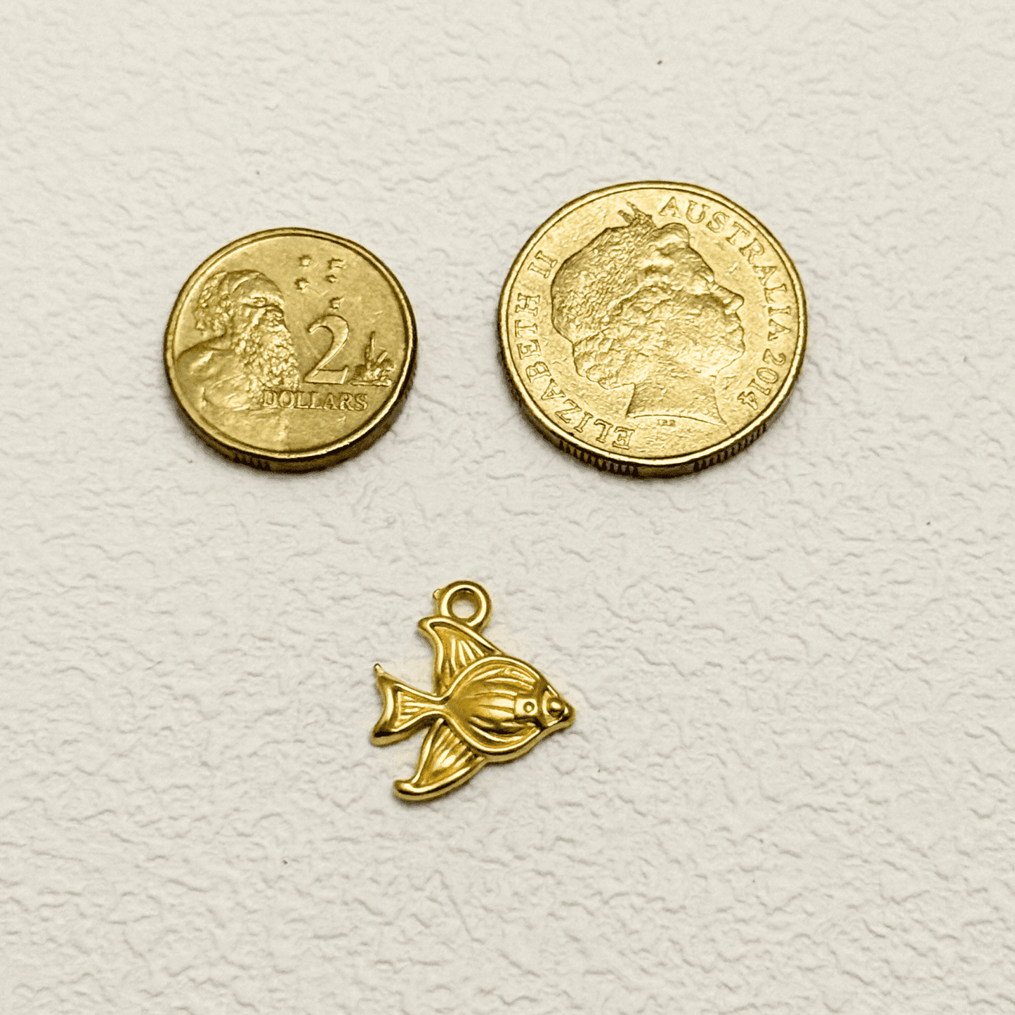 Gold angelfish charm with a smooth surface and detailed fin design