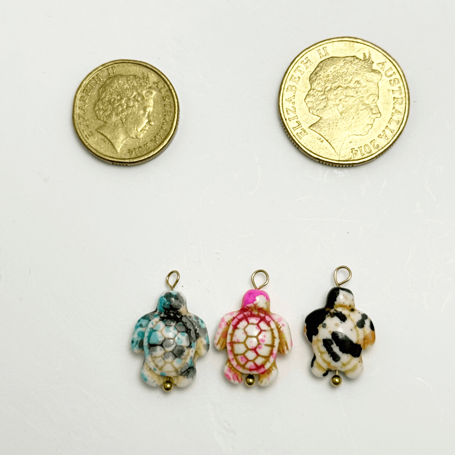 Turquoise-toned synthetic stone turtle charm with hexagonal mosaic shell pattern and gold bead detail
