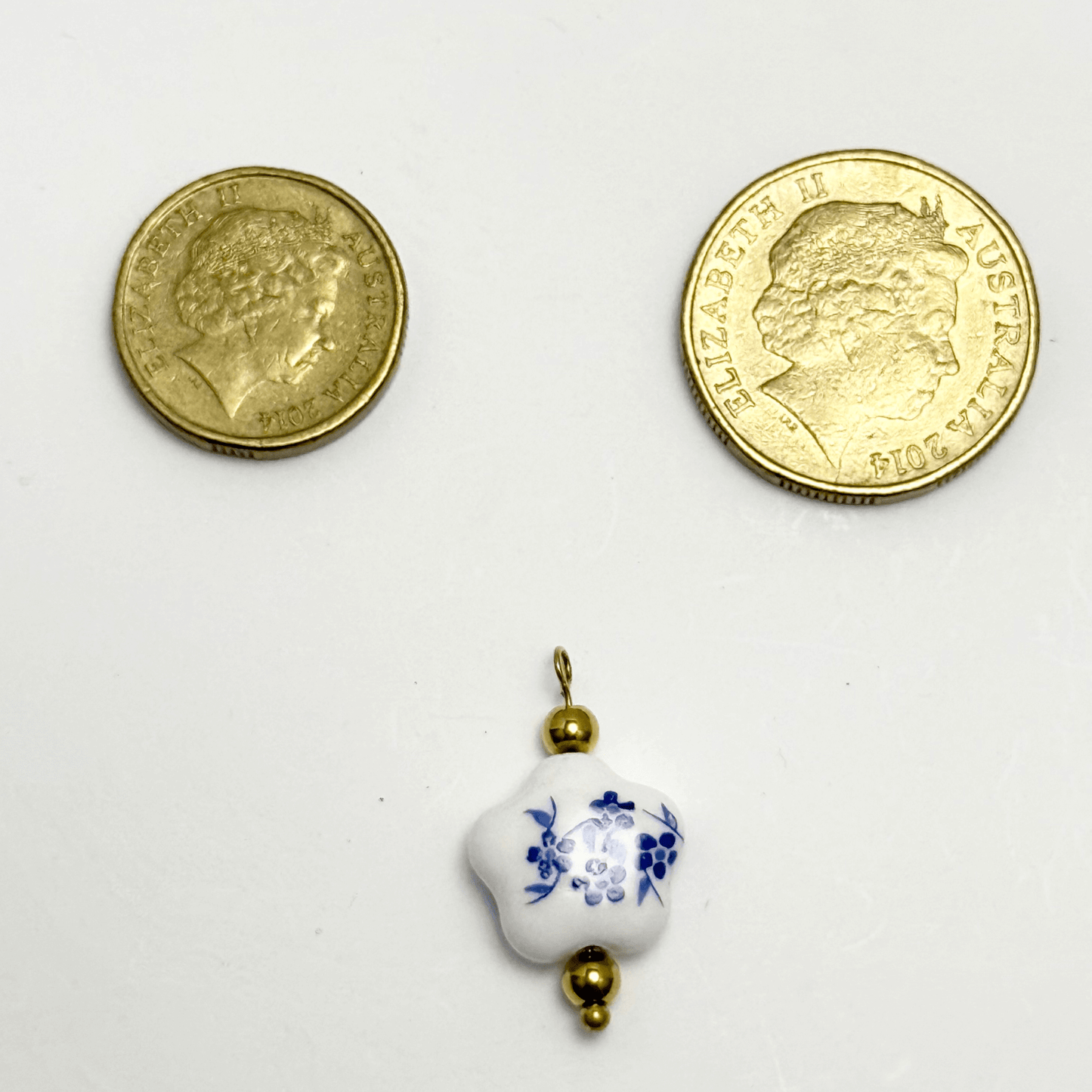 Star-shaped white ceramic charm with blue floral design and gold bead accents