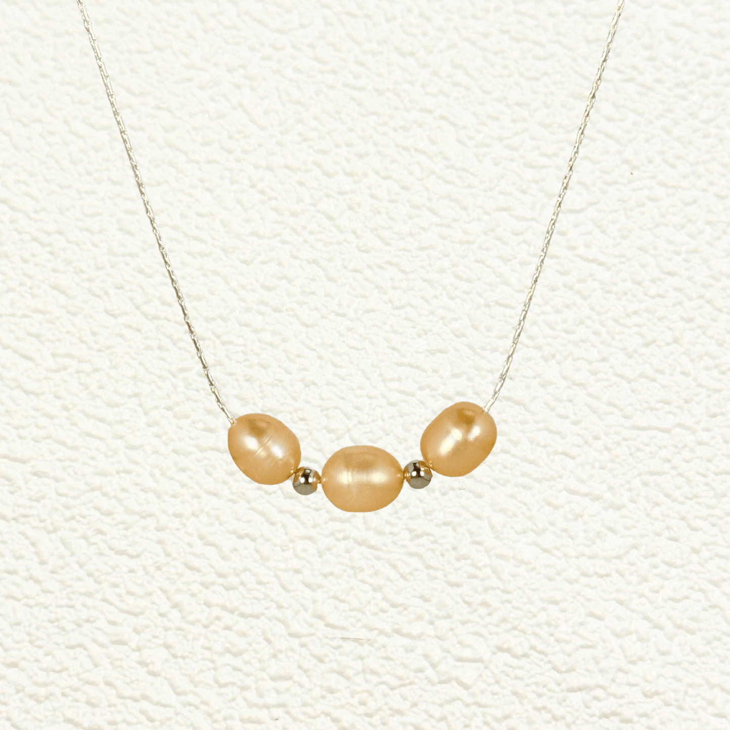 Blush pink freshwater pearl necklace with three pearls on a fine chain, available in gold filled and sterling silver options.