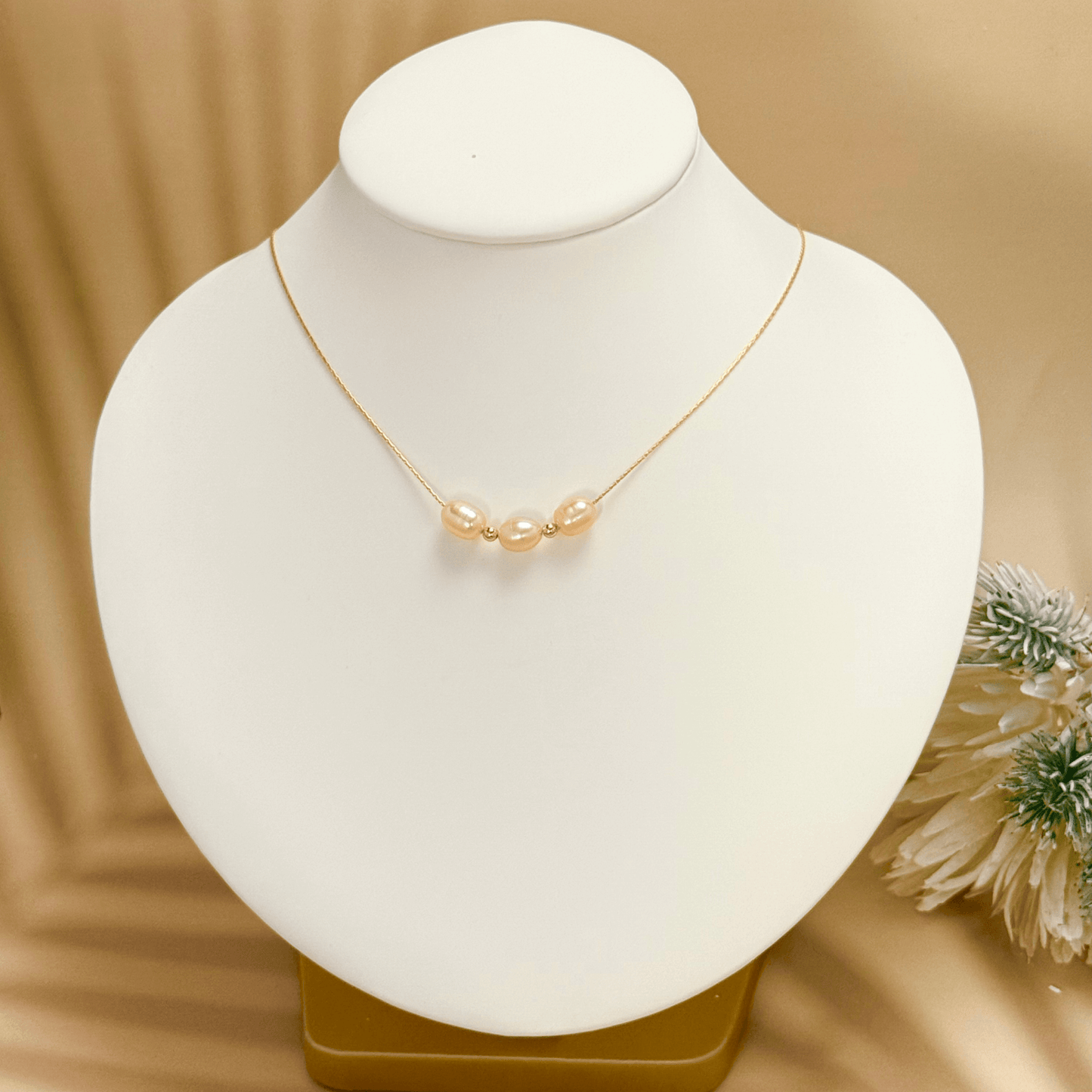 Blush pink freshwater pearl necklace with three pearls on a fine chain, available in gold filled and sterling silver options.