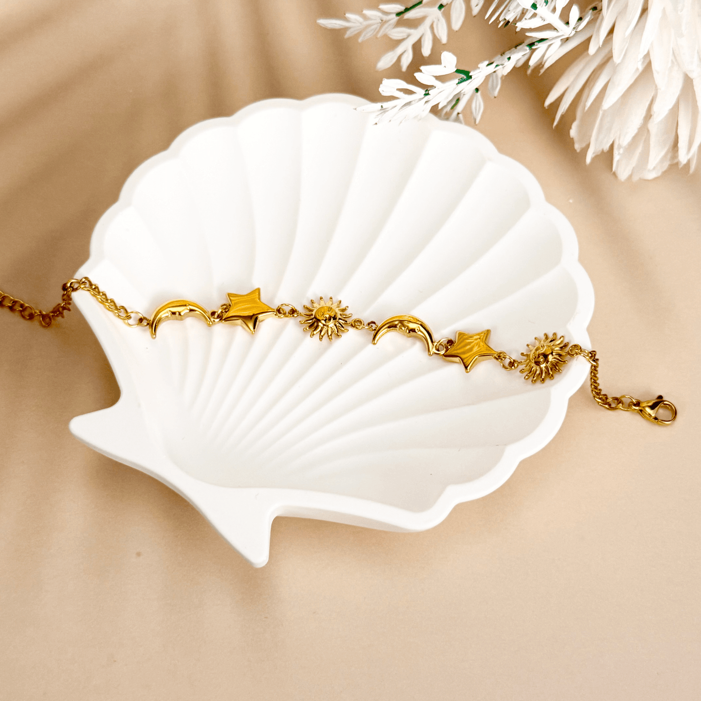 Waterproof gold celestial charm bracelet featuring sun, star, and crescent moon charms, made from PVD gold-plated stainless steel with an adjustable chain