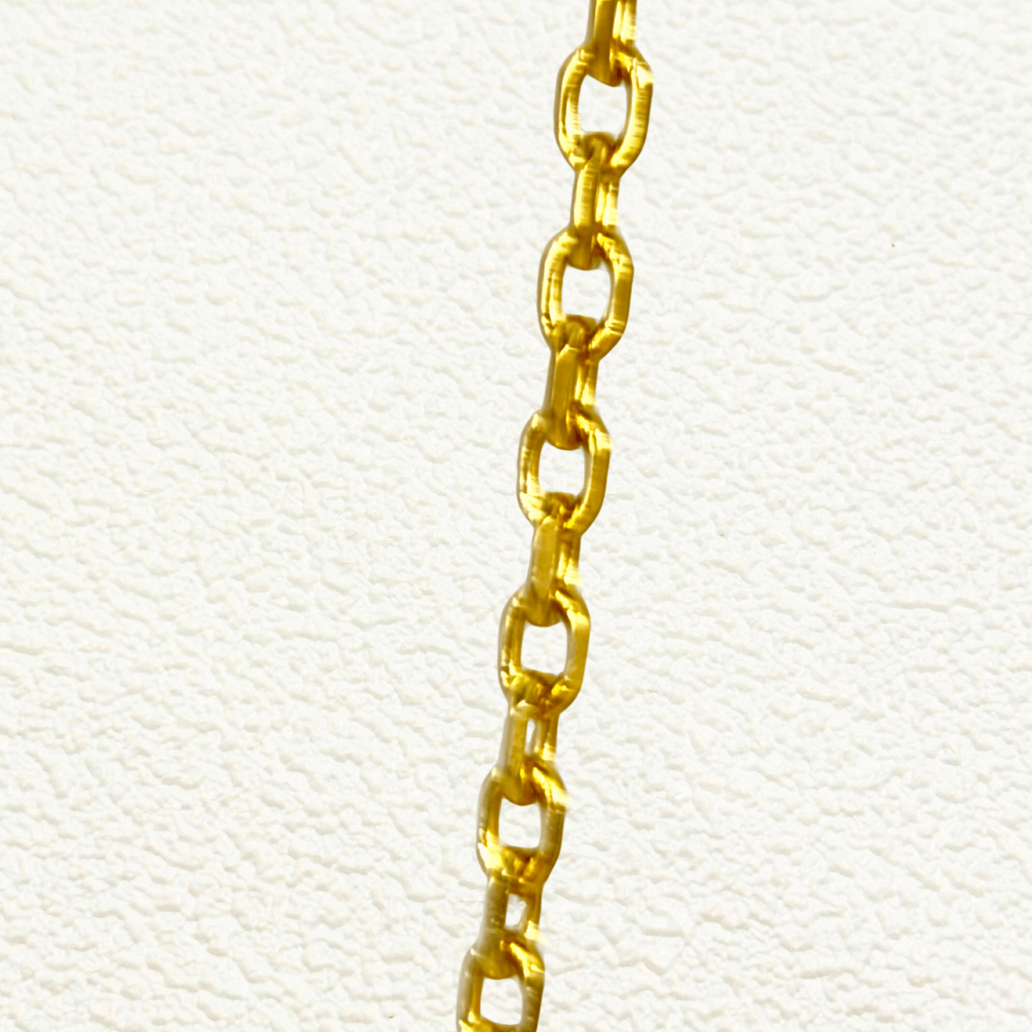 Gold cable chain made of fine interlocking links in a classic minimalist style, available as necklace, bracelet, or anklet