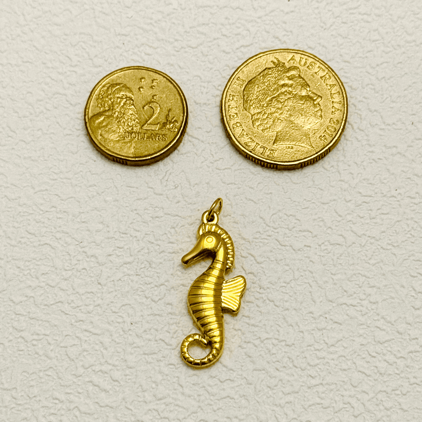 Gold Curled Fin Seahorse Charm with textured lines and raised eye detail