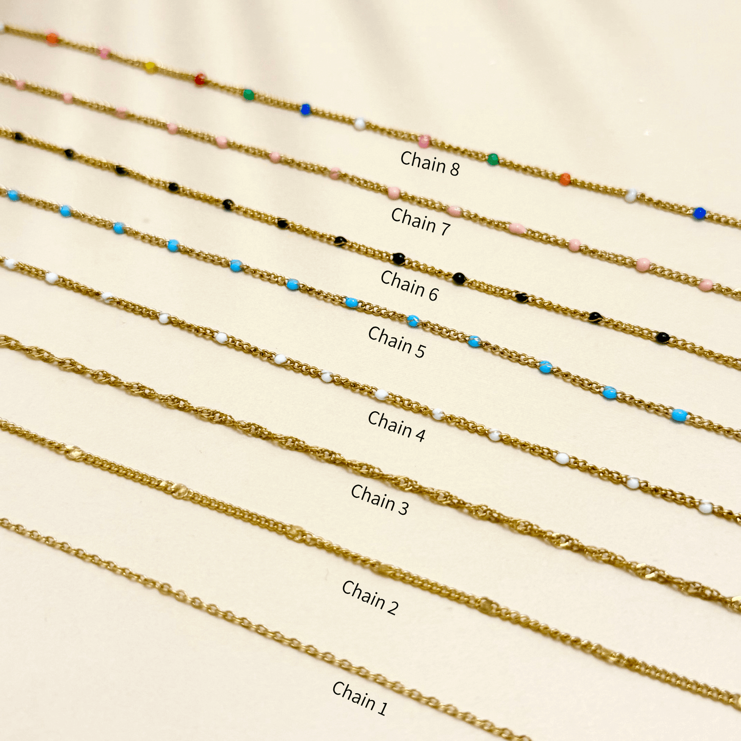 Mini gold charm necklace with evil eye, heart, pearl, star, and leaf on waterproof chain