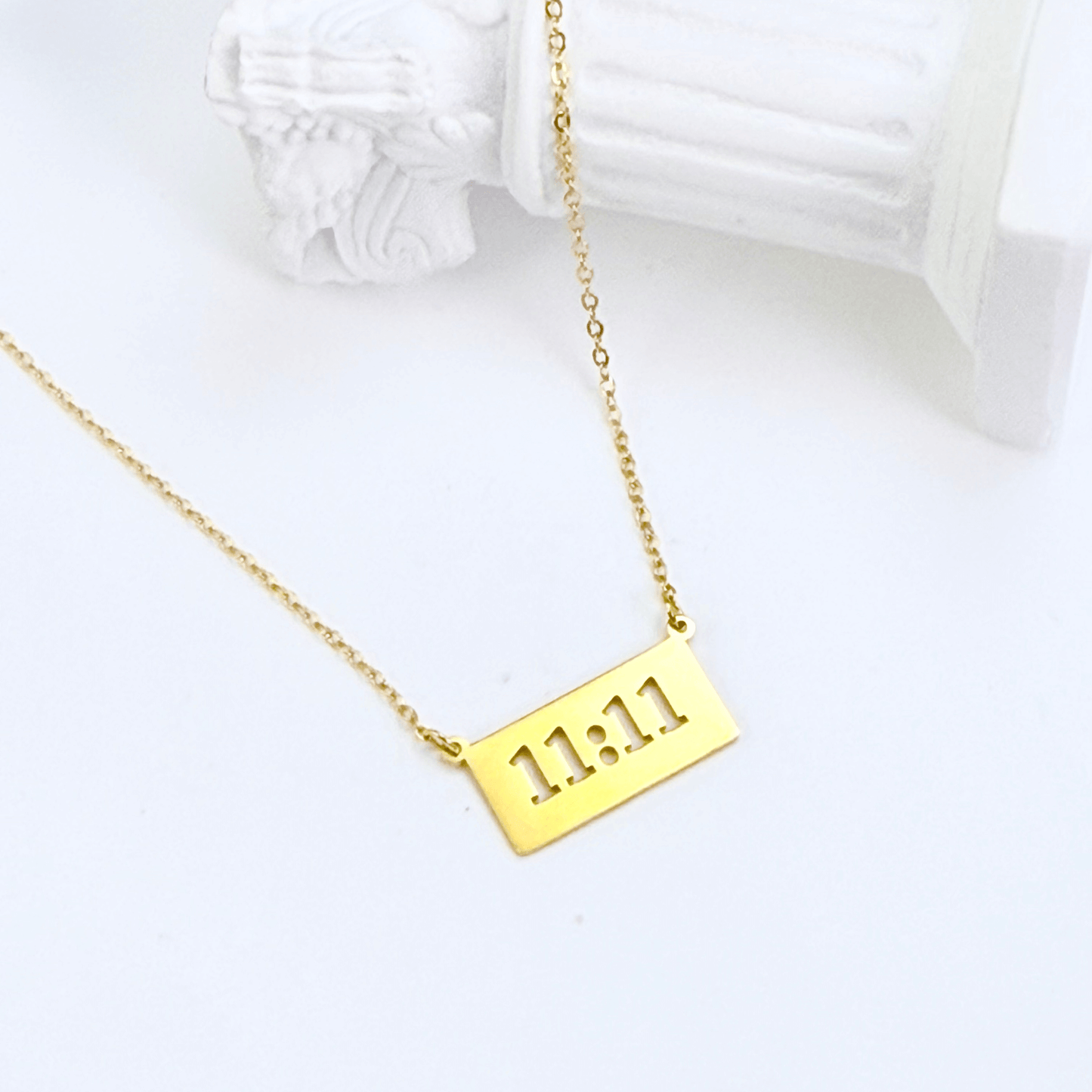 Gold 11:11 angel number necklace featuring a rectangular pendant on a dainty chain, symbolising manifestation and alignment.