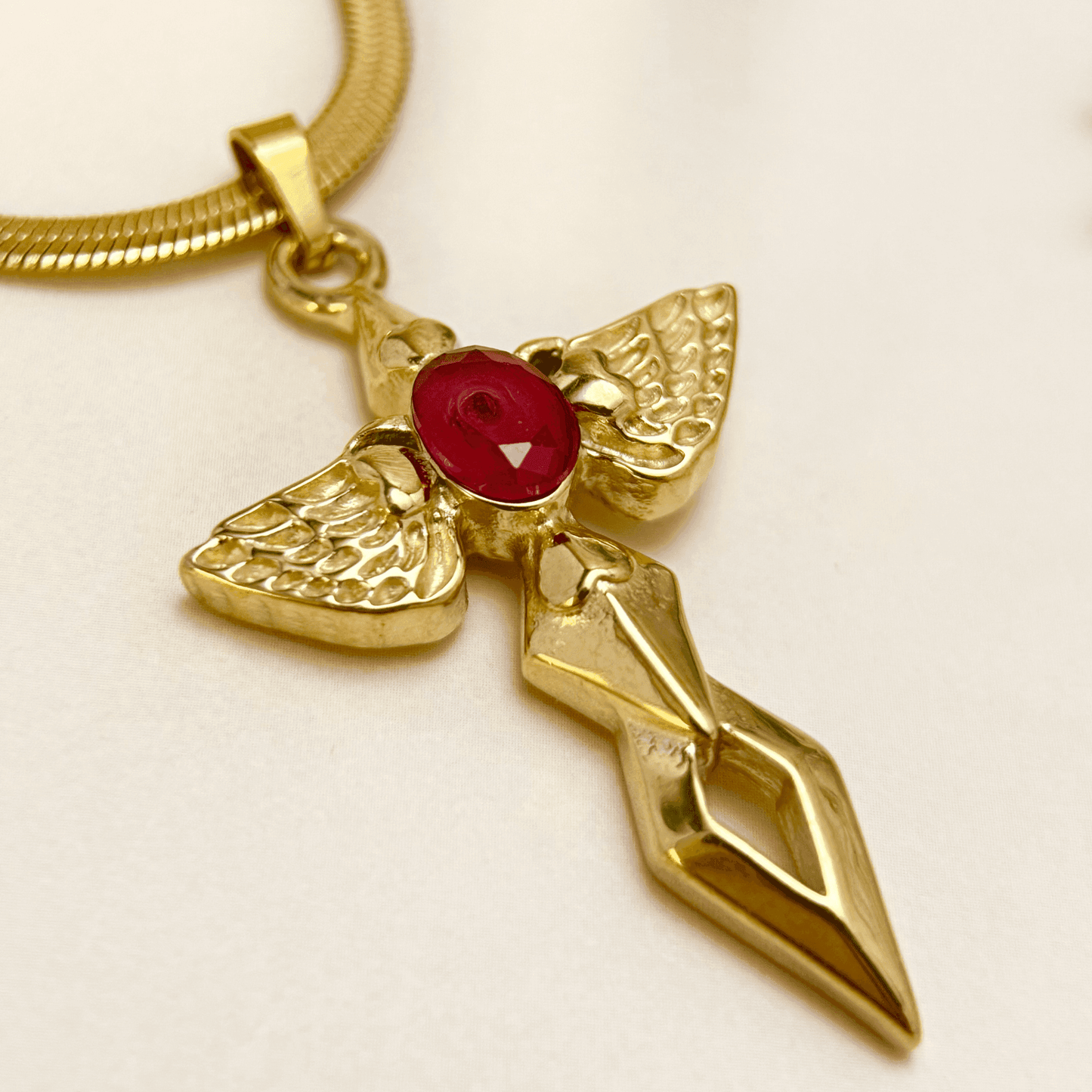 Gold angel wing cross pendant necklace with red zircon stone – spiritual gothic necklace with celestial symbolism