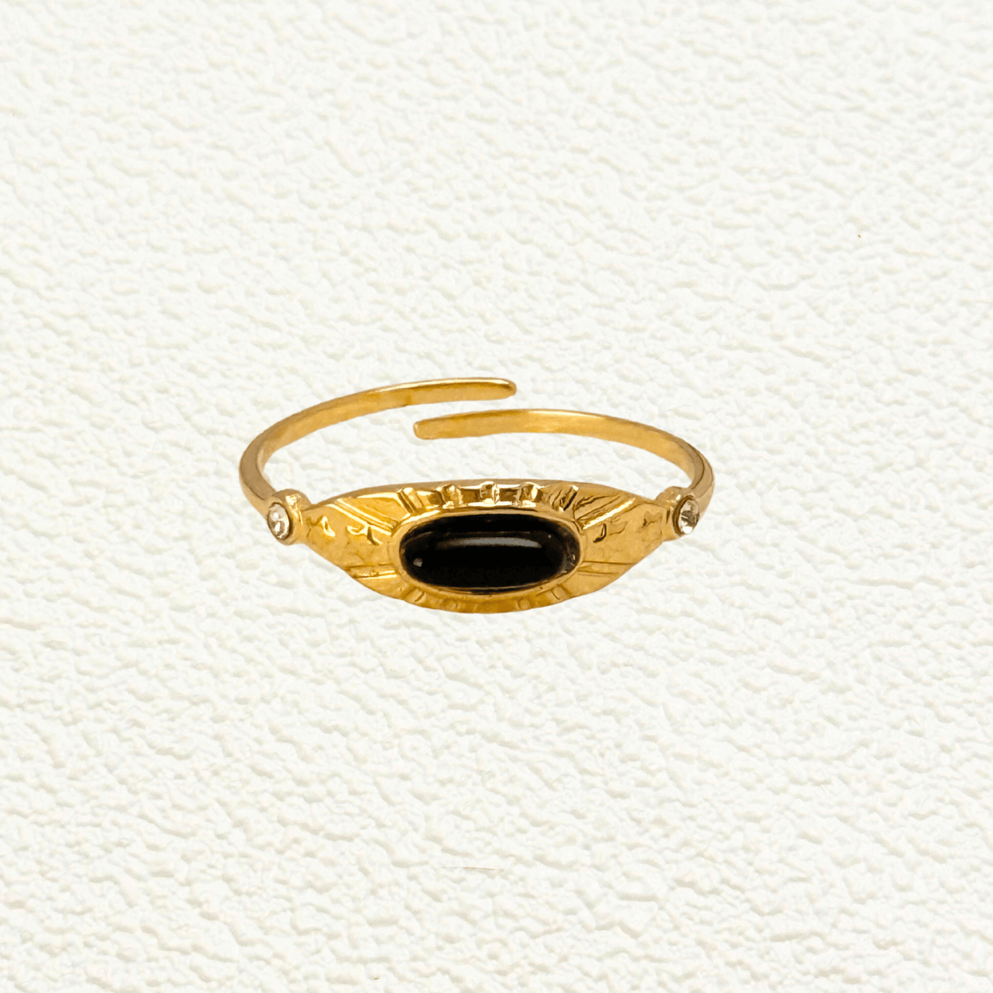Orion gold ring with oval black agate stone and sunburst engraving, adjustable open band design.