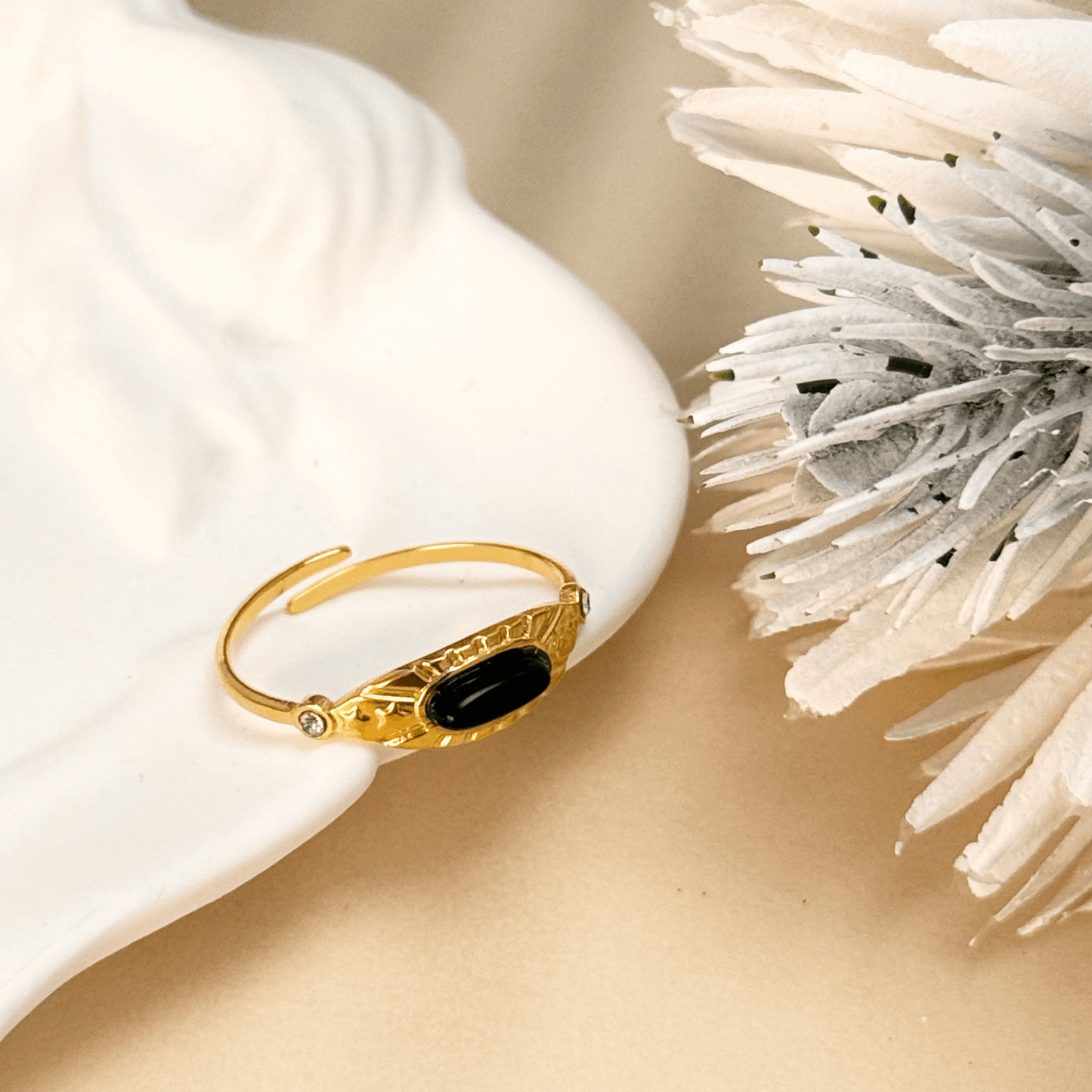 Orion gold ring with oval black agate stone and sunburst engraving, adjustable open band design.