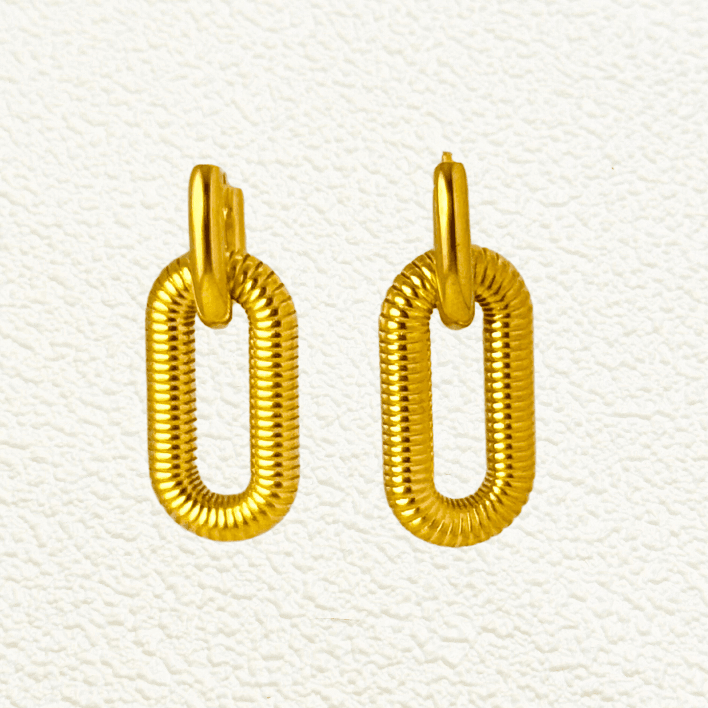 gold coil link hoop earrings in PVD gold plated stainless steel with oval coiled design, modern bold style, waterproof and tarnish-resistant