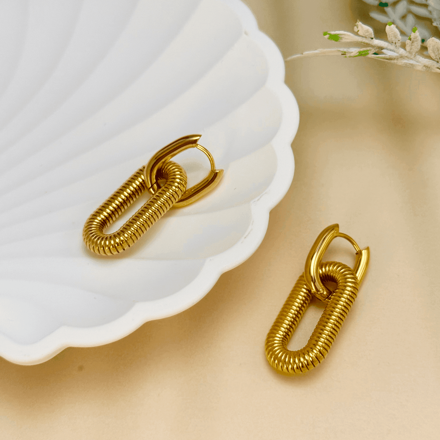 gold coil link hoop earrings in PVD gold plated stainless steel with oval coiled design, modern bold style, waterproof and tarnish-resistant