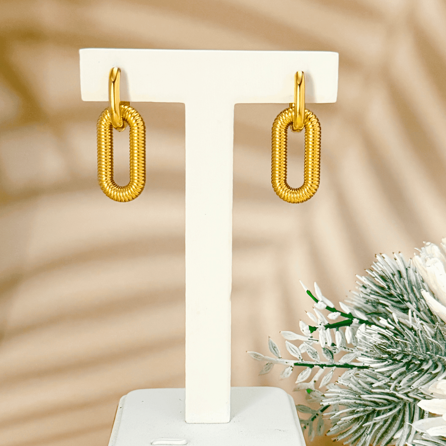 gold coil link hoop earrings in PVD gold plated stainless steel with oval coiled design, modern bold style, waterproof and tarnish-resistant