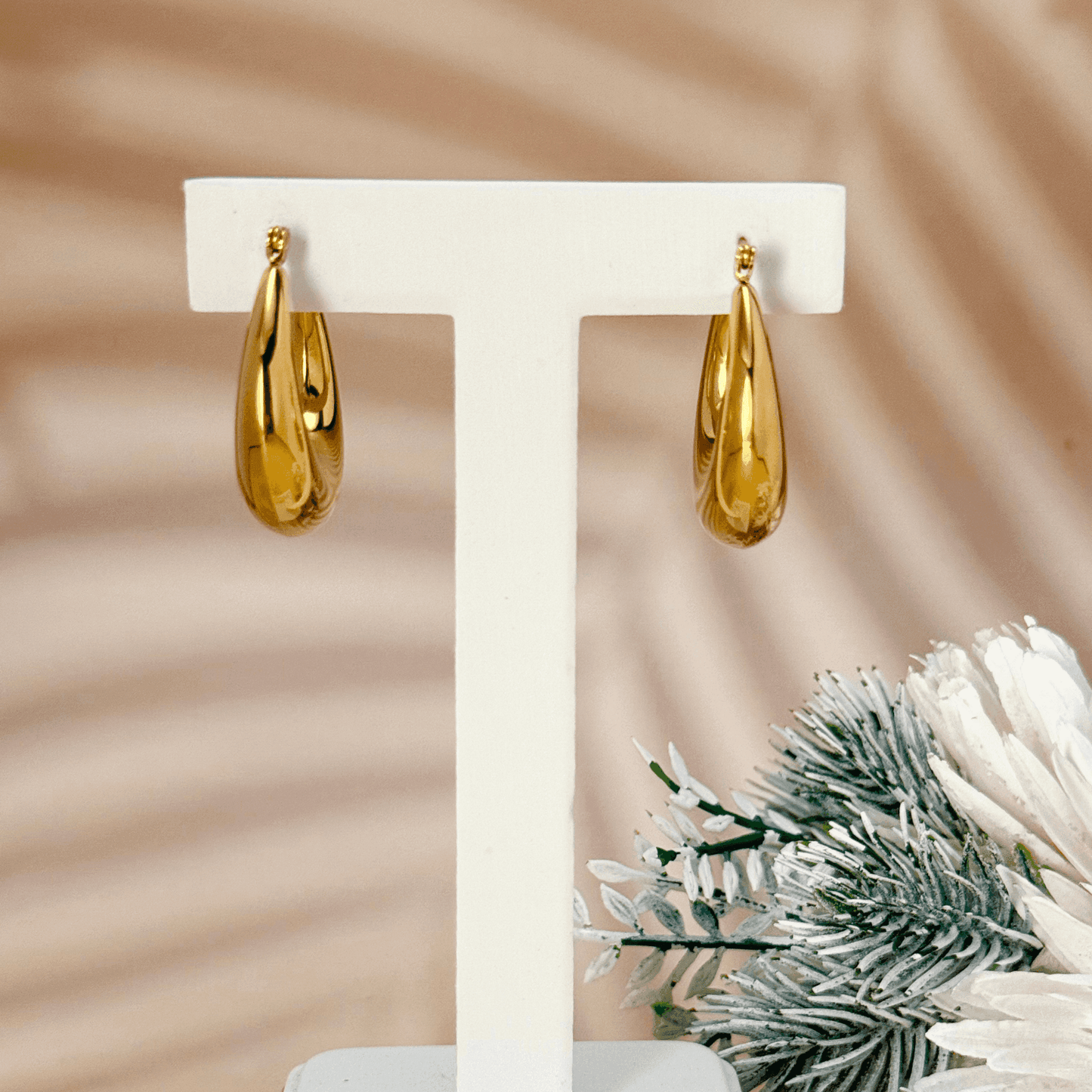 Gold crescent hoop earrings in sculptural design, made from PVD-plated stainless steel, bold modern statement jewelry for women