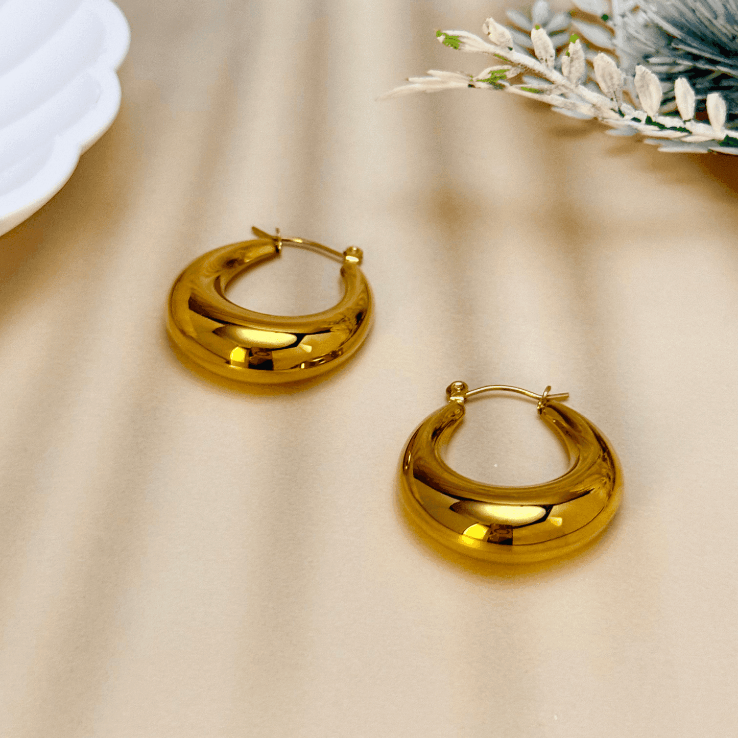 Gold crescent hoop earrings in sculptural design, made from PVD-plated stainless steel, bold modern statement jewelry for women