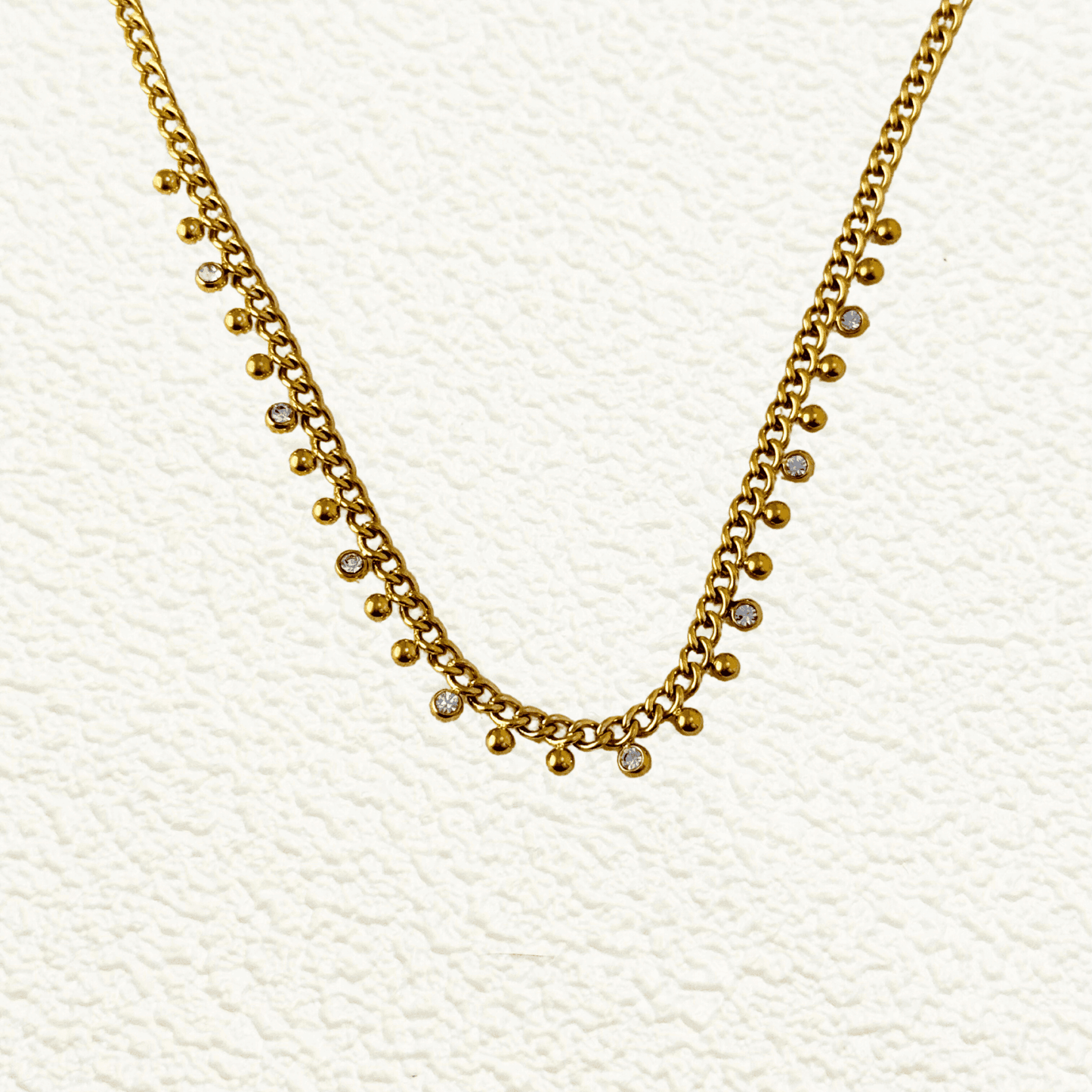 Elegant gold necklace featuring a cable chain adorned with zircon charms and gold beads, crafted from gold-plated stainless steel for a timeless and sophisticated look.