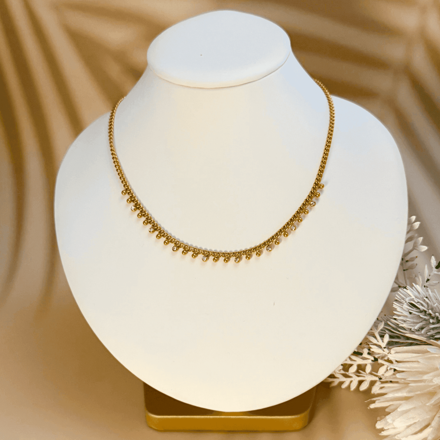Elegant gold necklace featuring a cable chain adorned with zircon charms and gold beads, crafted from gold-plated stainless steel for a timeless and sophisticated look.