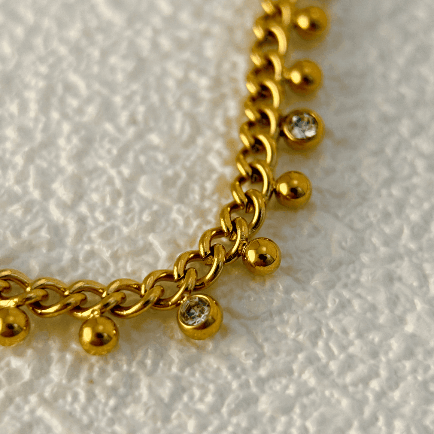 Elegant gold necklace featuring a cable chain adorned with zircon charms and gold beads, crafted from gold-plated stainless steel for a timeless and sophisticated look.