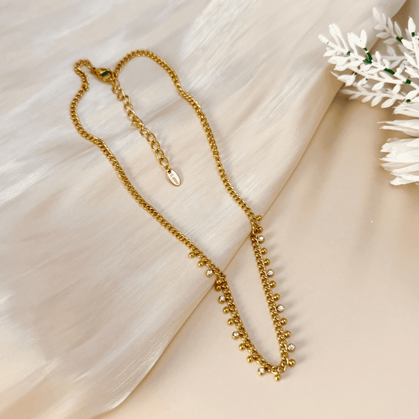 Elegant gold necklace featuring a cable chain adorned with zircon charms and gold beads, crafted from gold-plated stainless steel for a timeless and sophisticated look.