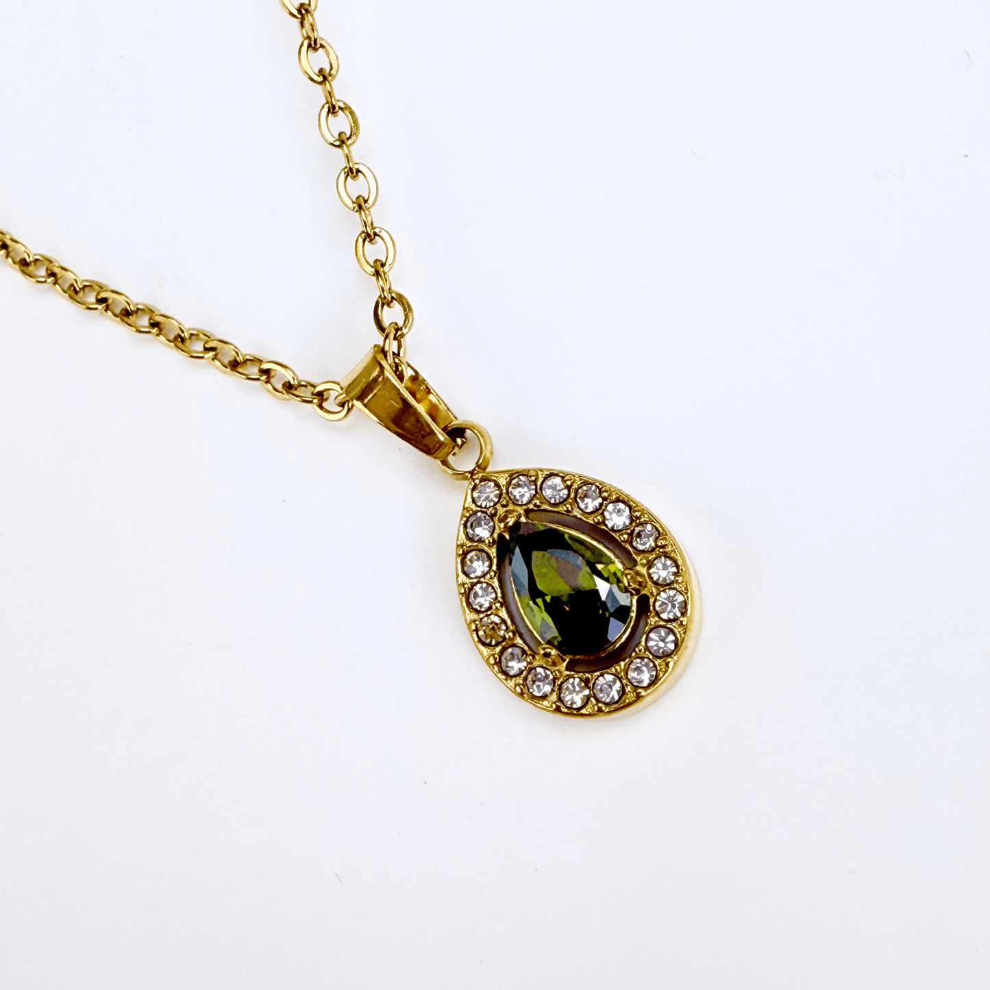 gold emerald glow teardrop necklace with green gemstone surrounded by clear crystals on gold chain
