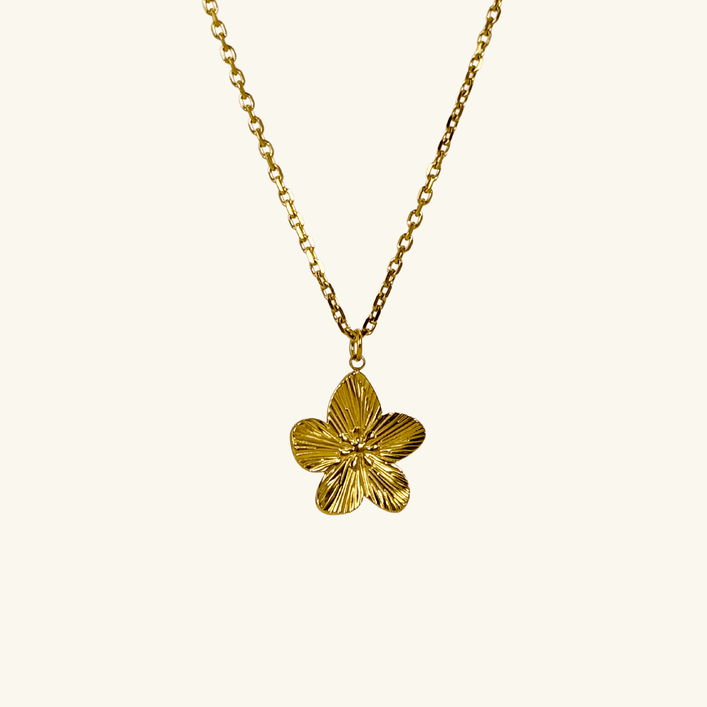 Gold flower pendant necklace on model, waterproof floral jewellery with dainty chain