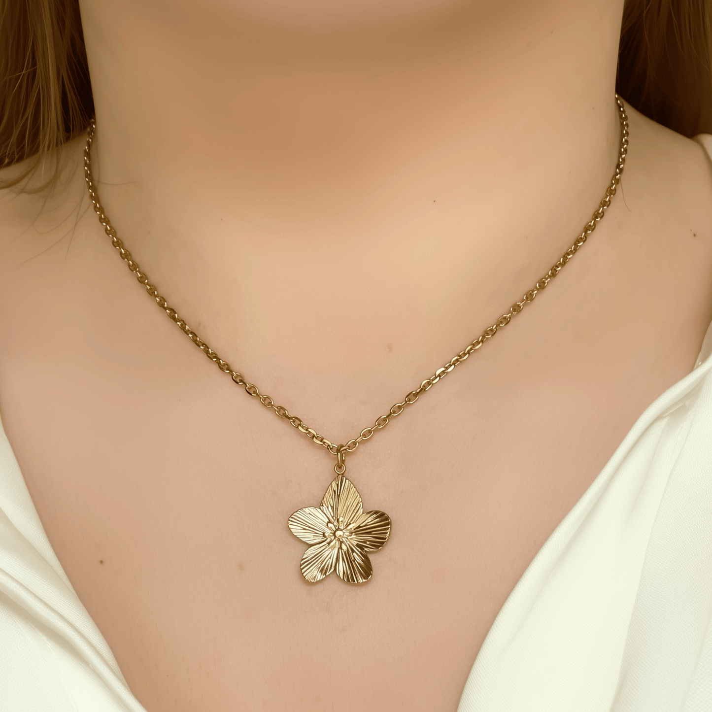 Gold flower pendant necklace on model, waterproof floral jewellery with dainty chain