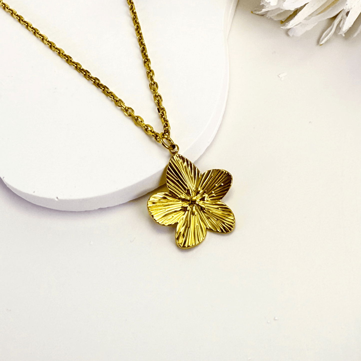 Gold flower pendant necklace on model, waterproof floral jewellery with dainty chain