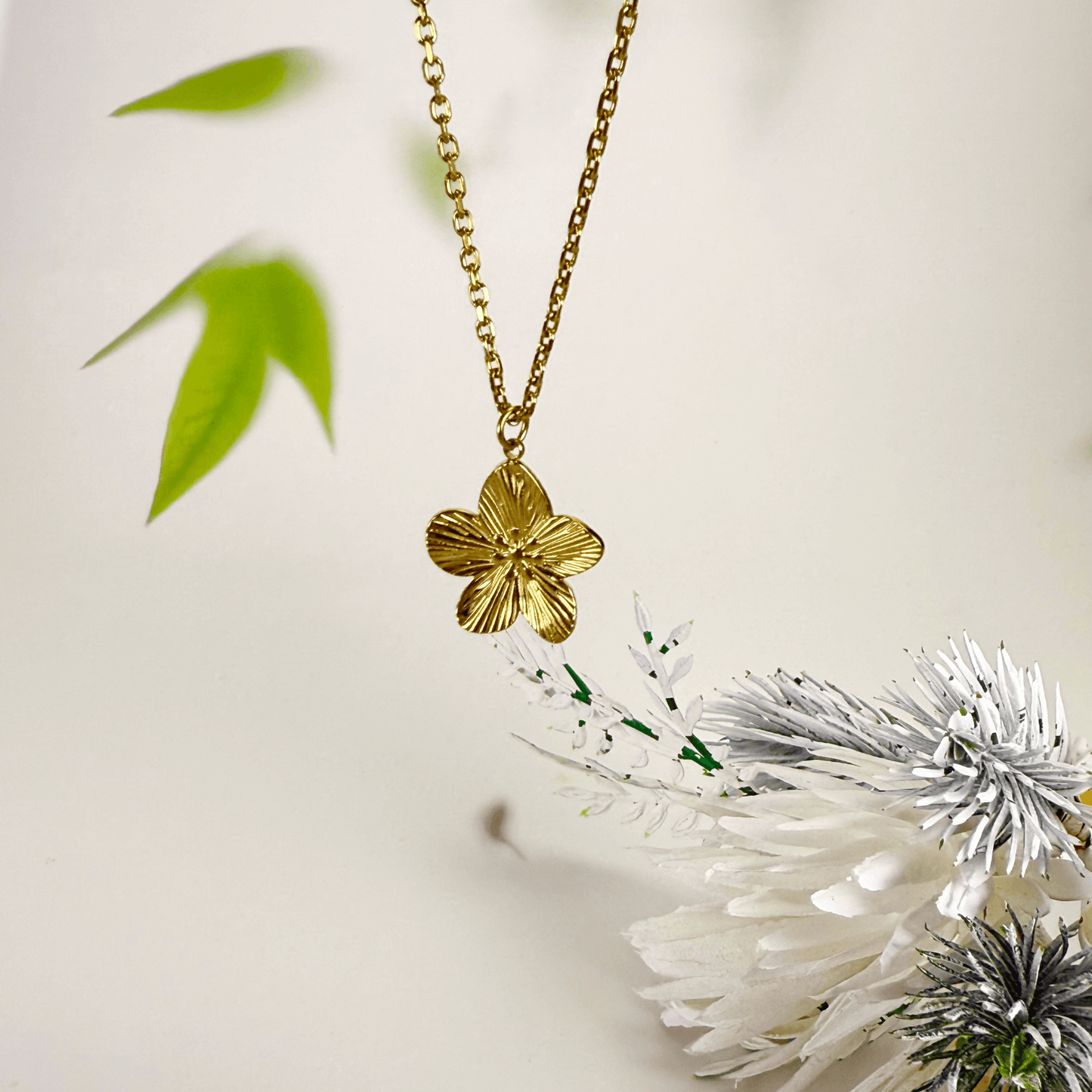 Gold flower pendant necklace on model, waterproof floral jewellery with dainty chain
