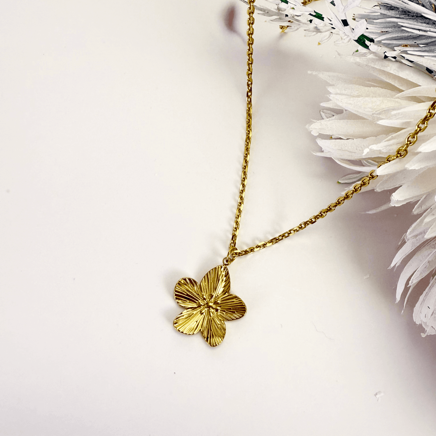 Gold flower pendant necklace on model, waterproof floral jewellery with dainty chain