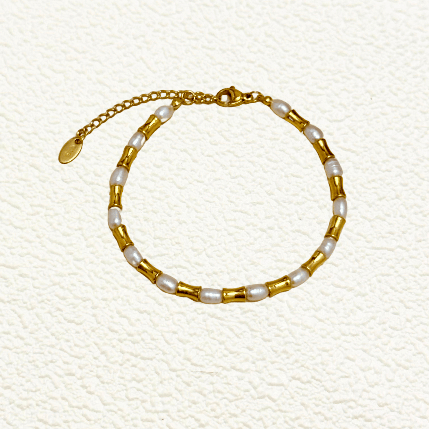 Gold and freshwater pearl bracelet with tube beads, waterproof and minimalist design.