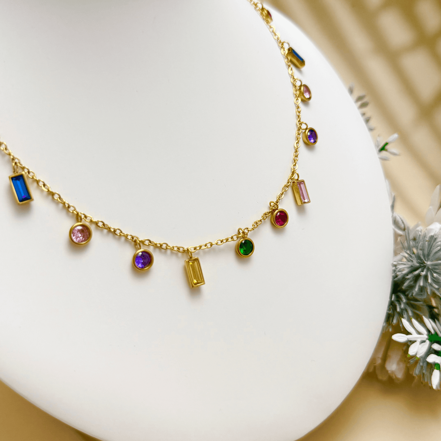 Gold multicolour zircon charm necklace with vibrant round and baguette zircon stones on a gold-plated stainless steel chain. Waterproof and hypoallergenic jewellery.