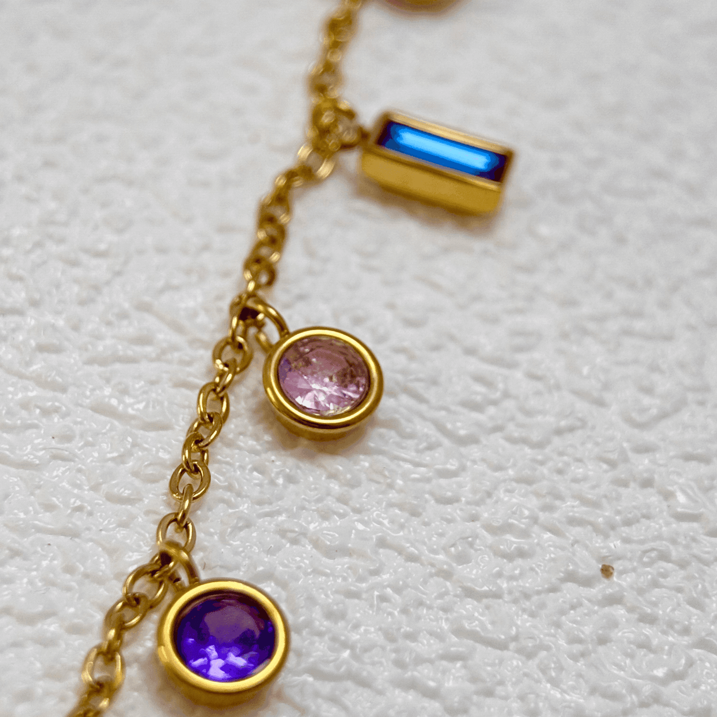 Gold multicolour zircon charm necklace with vibrant round and baguette zircon stones on a gold-plated stainless steel chain. Waterproof and hypoallergenic jewellery.