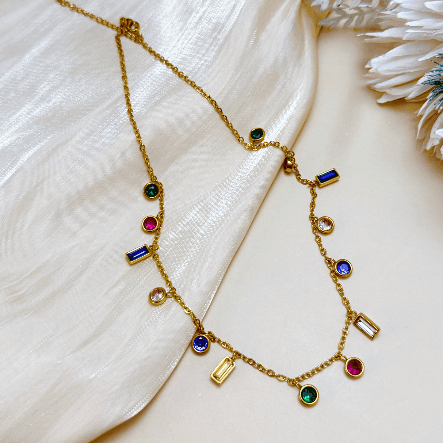 Gold multicolour zircon charm necklace with vibrant round and baguette zircon stones on a gold-plated stainless steel chain. Waterproof and hypoallergenic jewellery.