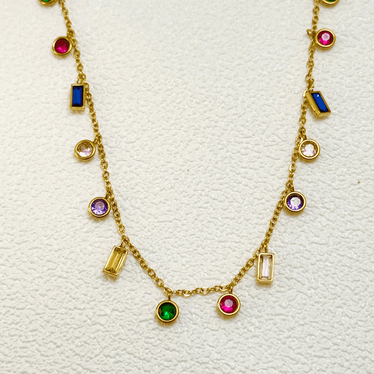 Gold multicolour zircon charm necklace with vibrant round and baguette zircon stones on a gold-plated stainless steel chain. Waterproof and hypoallergenic jewellery.