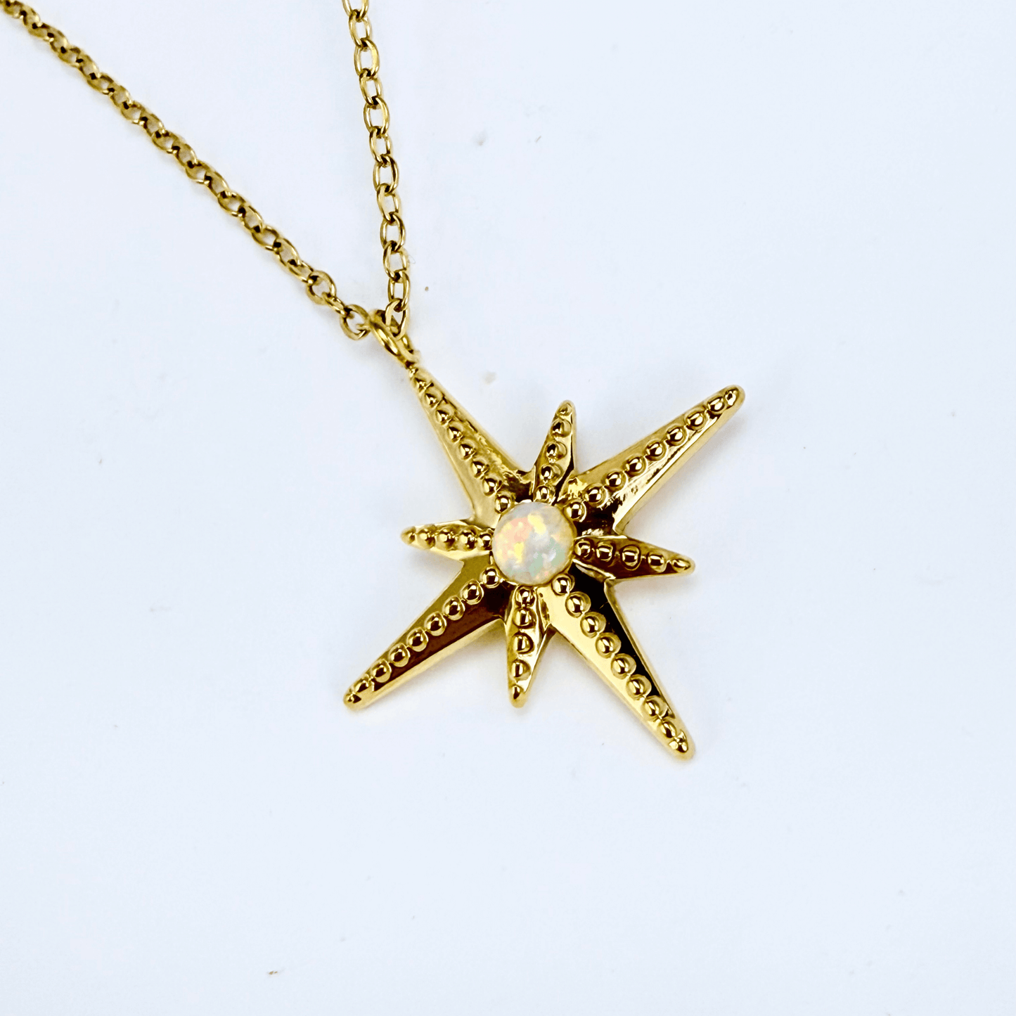 Gold North Star pendant necklace with luminous glass centre, symbolising guidance, balance, and hope.