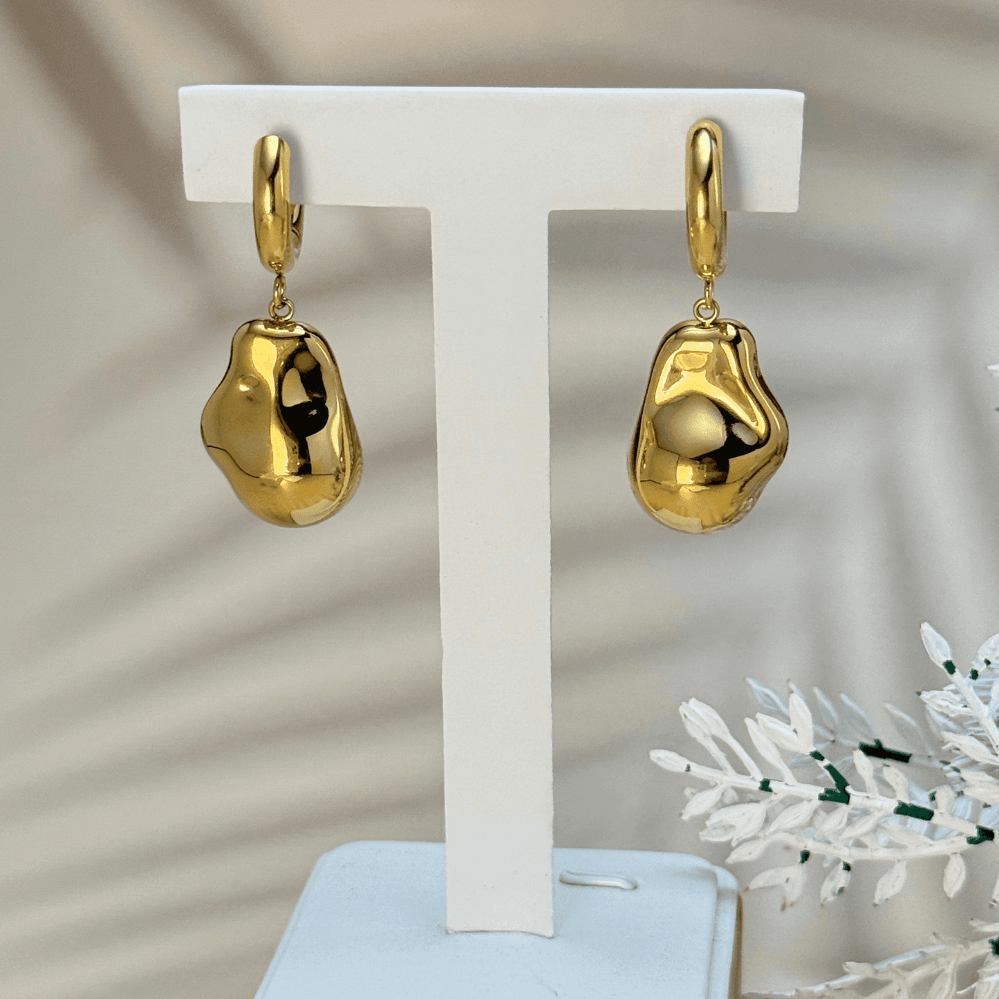 Waterproof gold-plated organic drop earrings with a sculptural molten metal design, featuring huggie hoop fastening.