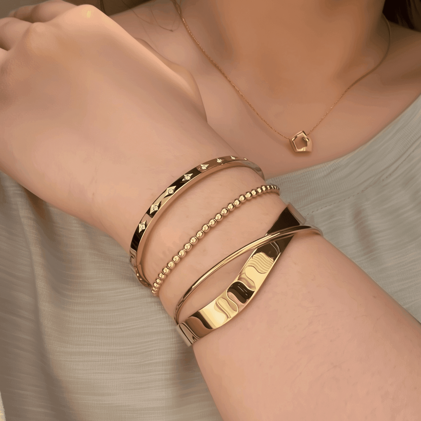 A collection of gold-plated bangles from MXW Jewellery, featuring zircon accents, Roman numerals, and smooth polished finishes, waterproof and tarnish-free.