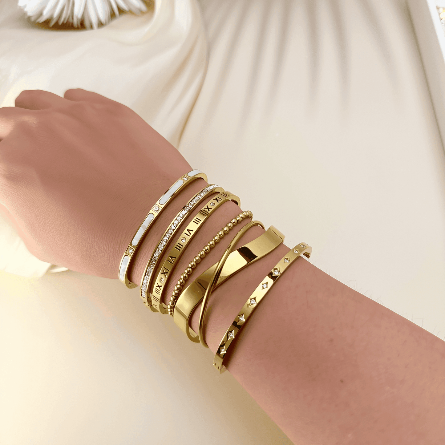 A collection of gold-plated bangles from MXW Jewellery, featuring zircon accents, Roman numerals, and smooth polished finishes, waterproof and tarnish-free.