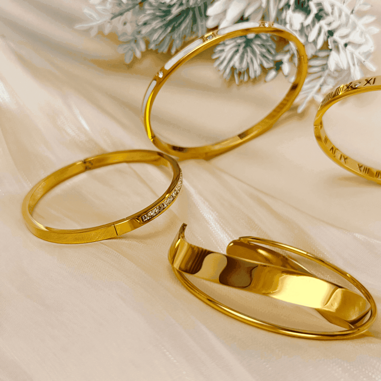 A collection of gold-plated bangles from MXW Jewellery, featuring zircon accents, Roman numerals, and smooth polished finishes, waterproof and tarnish-free.