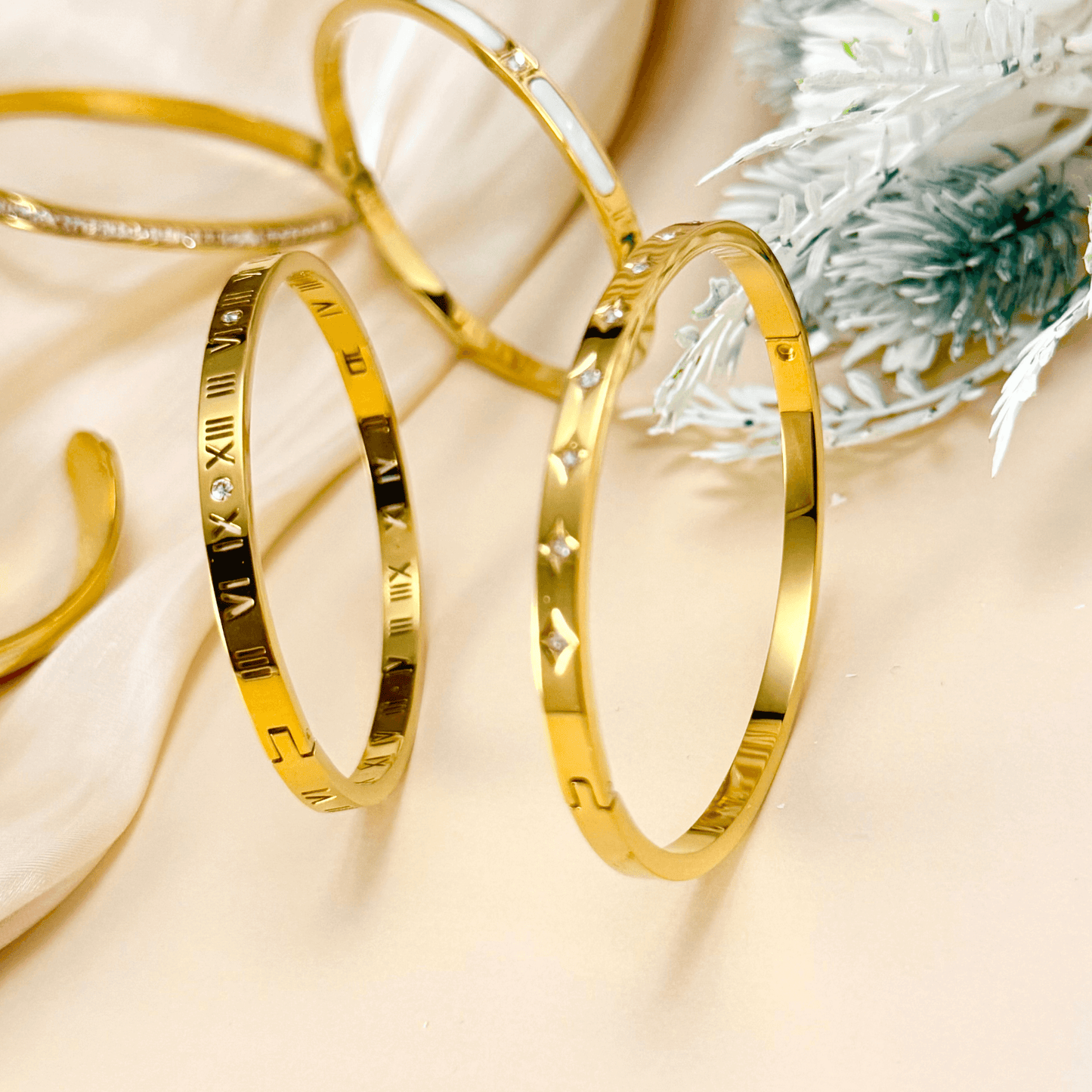 A collection of gold-plated bangles from MXW Jewellery, featuring zircon accents, Roman numerals, and smooth polished finishes, waterproof and tarnish-free.
