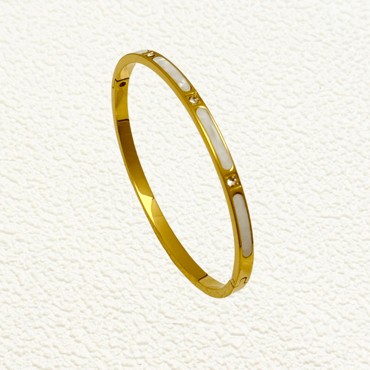 Gold shell inlay bangle with zircon stones, crafted from waterproof, tarnish-resistant stainless steel. Features a hinged clasp for secure fit, perfect for stacking or wearing alone.