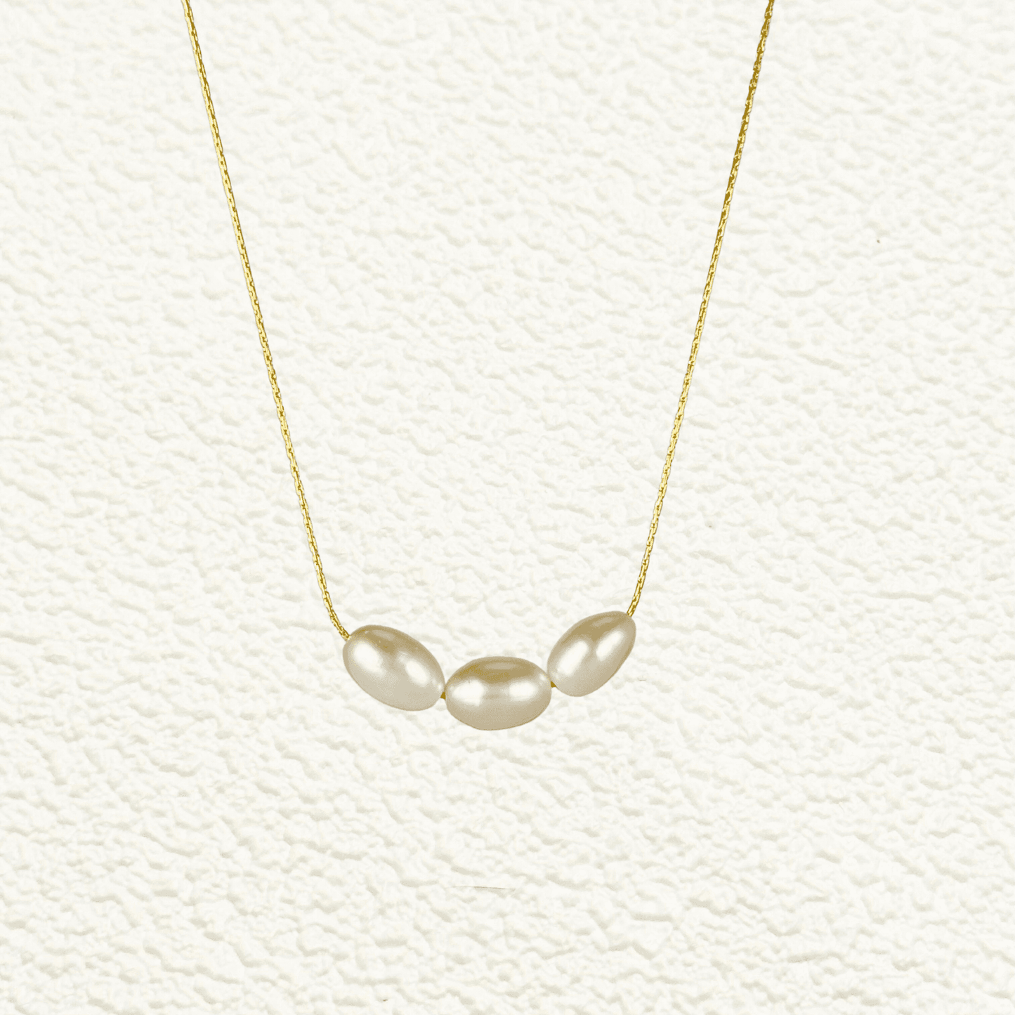 Gold and silver minimalist necklace with trio of 8–9 mm freshwater rice pearls, dainty and elegant for everyday wear or gifting.