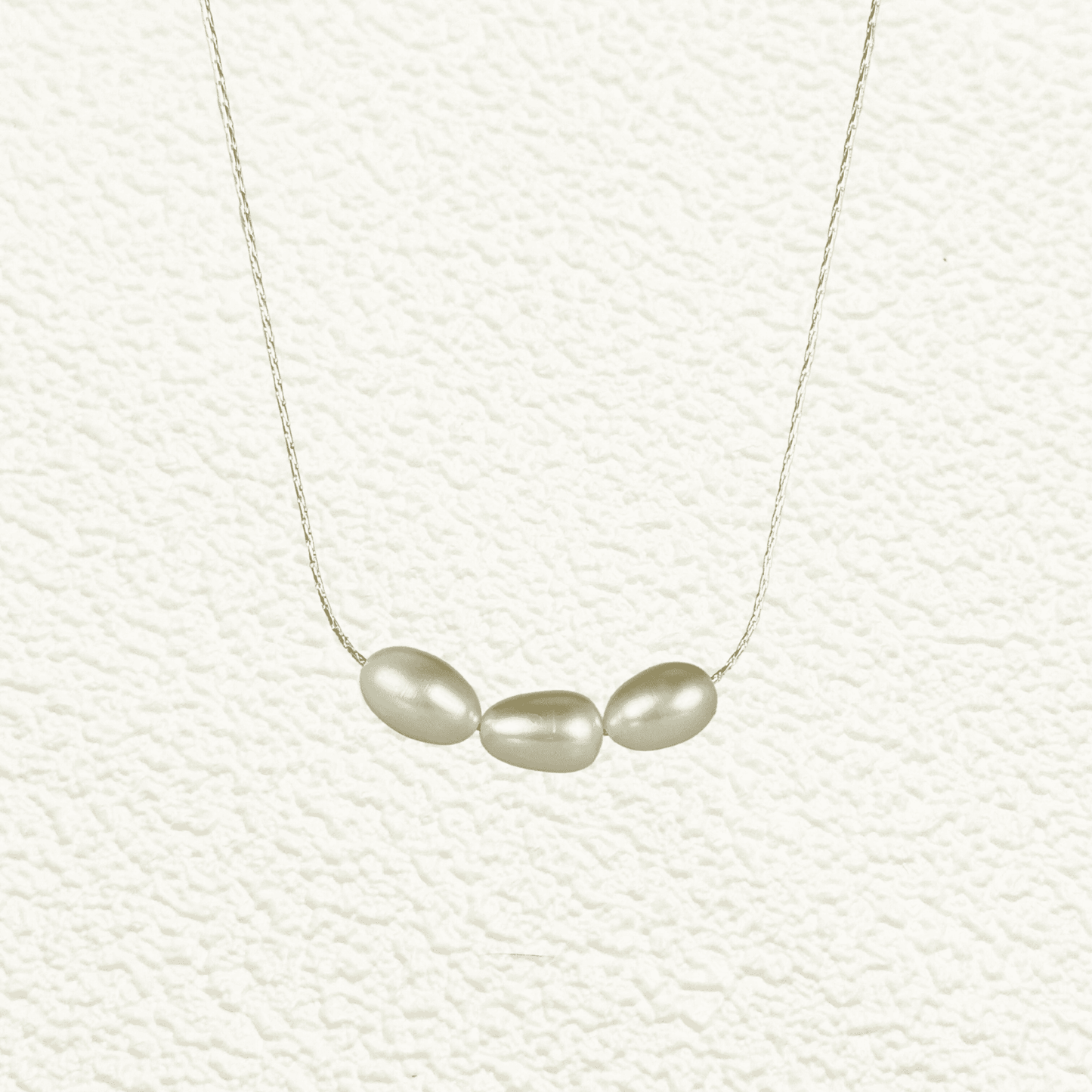 Gold and silver minimalist necklace with trio of 8–9 mm freshwater rice pearls, dainty and elegant for everyday wear or gifting.