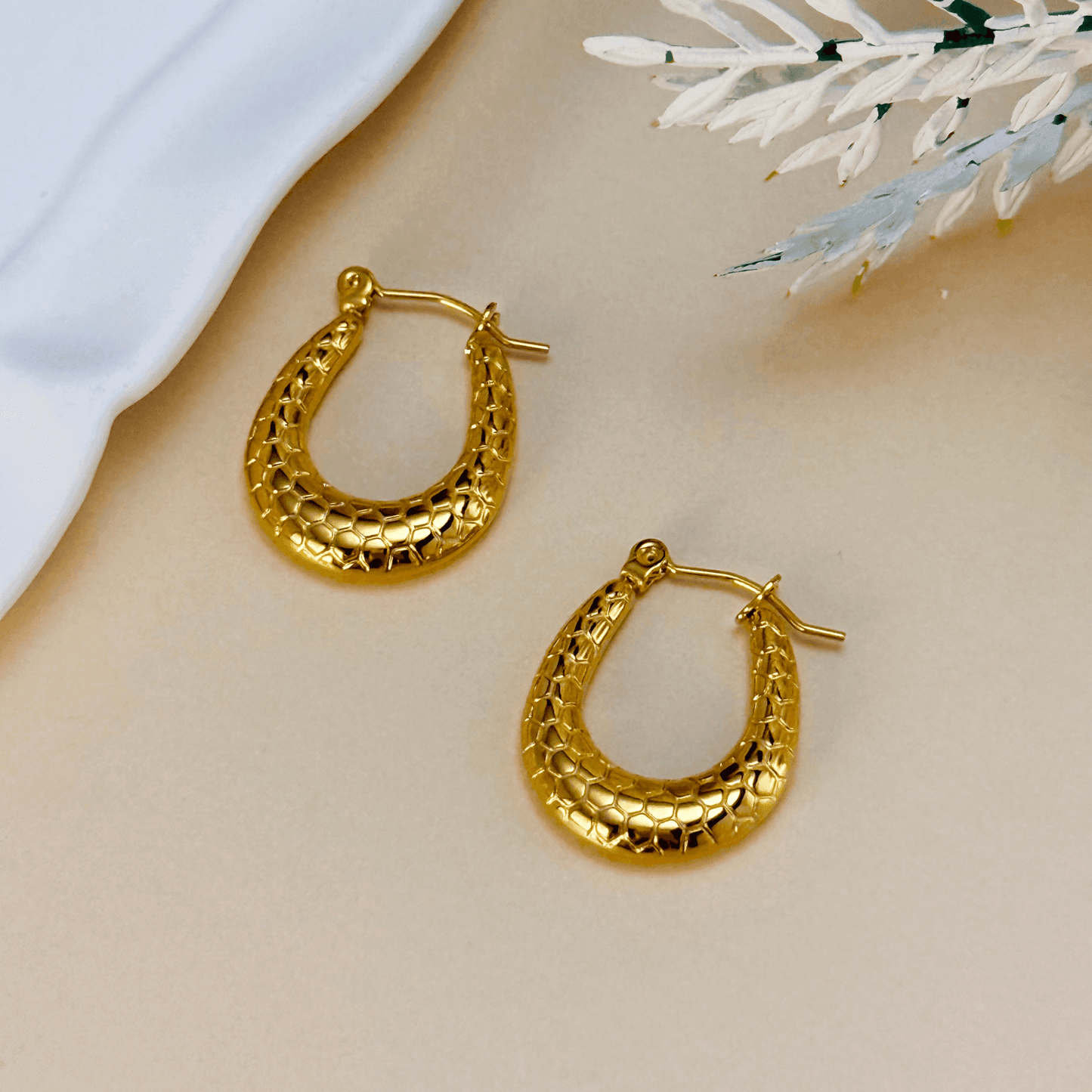 Gold textured hoop earrings with a honeycomb pattern, waterproof and hypoallergenic. Perfect for everyday wear and layering.
