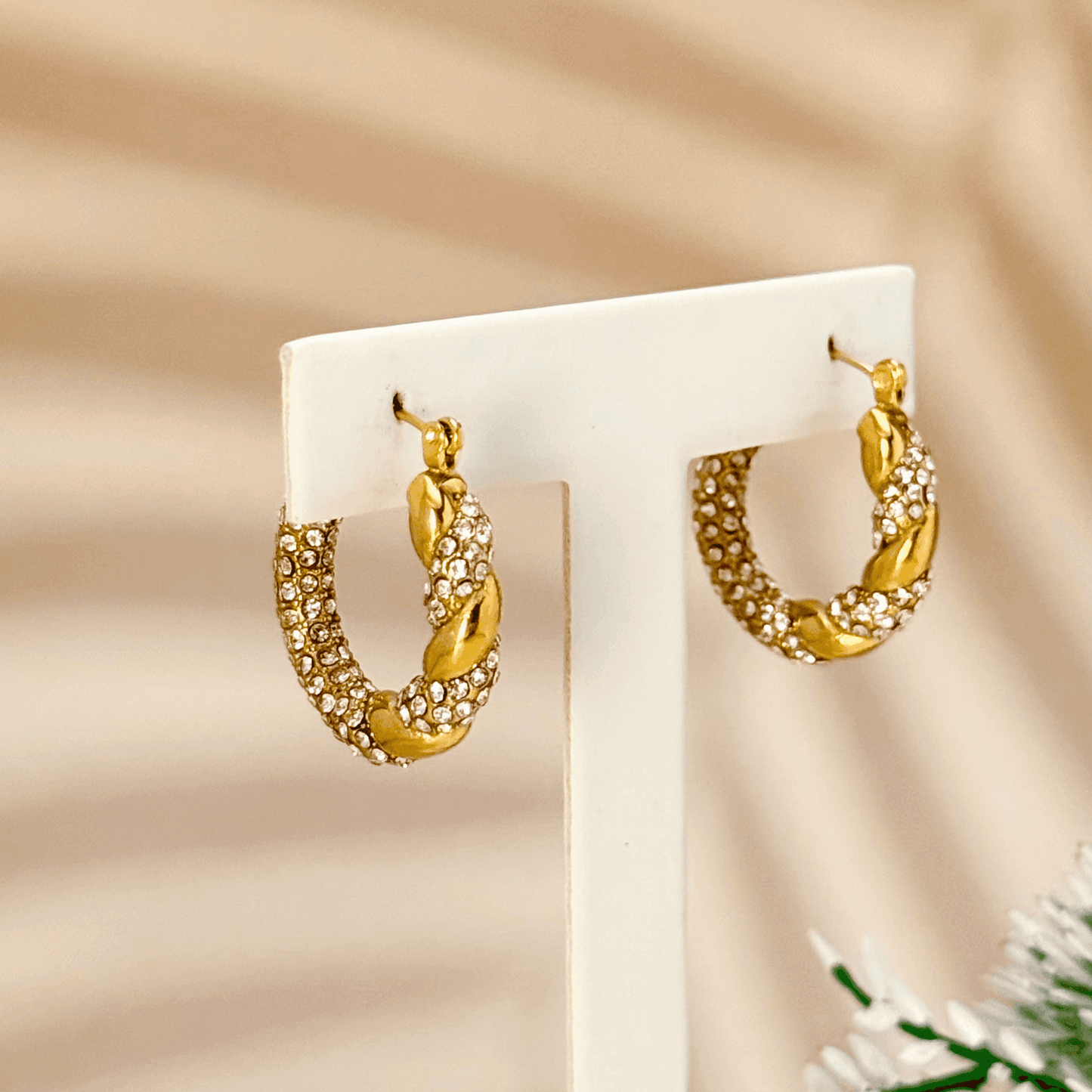 Gold twisted hoop earrings with zircon stones, crafted from PVD gold-plated stainless steel. Elegant, sparkling, and waterproof design for everyday wear.