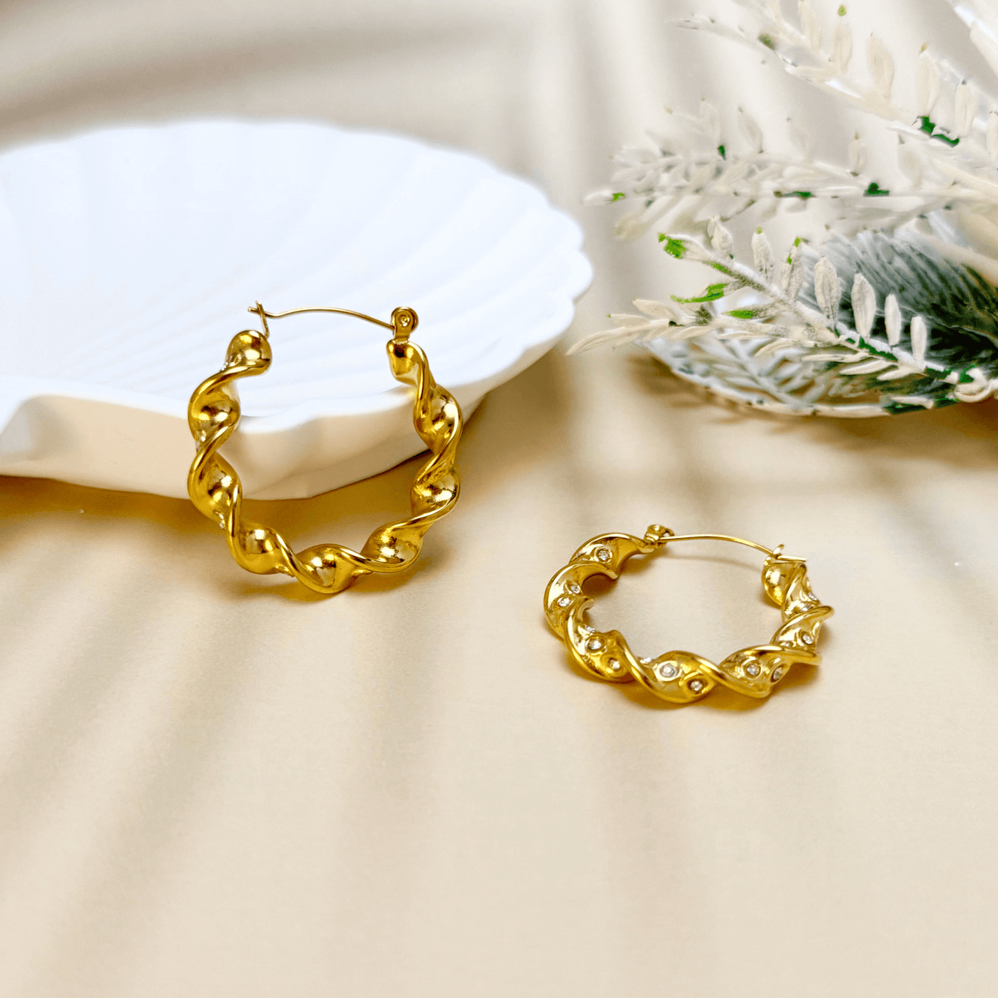 Gold twisted zircon hoop earrings made of waterproof stainless steel with a wave-like design and sparkling zircon stones.