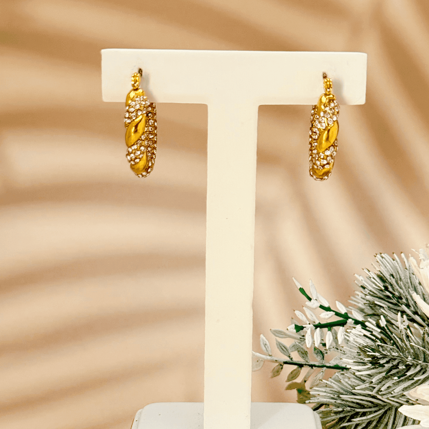 Gold twisted hoop earrings with zircon stones, crafted from PVD gold-plated stainless steel. Elegant, sparkling, and waterproof design for everyday wear.
