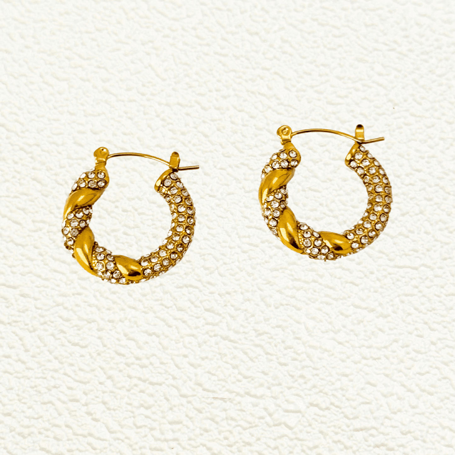 Gold twisted hoop earrings with zircon stones, crafted from PVD gold-plated stainless steel. Elegant, sparkling, and waterproof design for everyday wear.