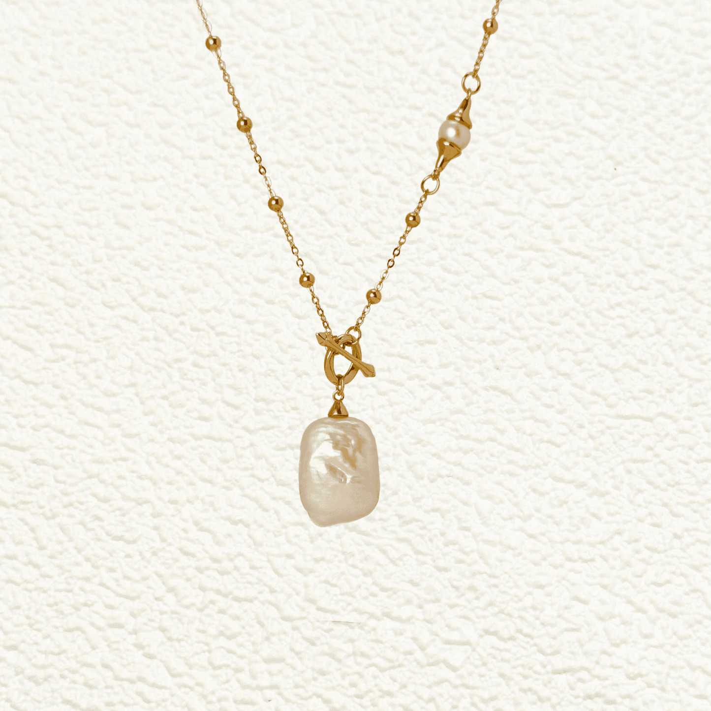 Gold vintage baroque pearl necklace with freshwater pearl pendant on a satellite bead chain and a toggle clasp, crafted in gold-plated sterling silver.