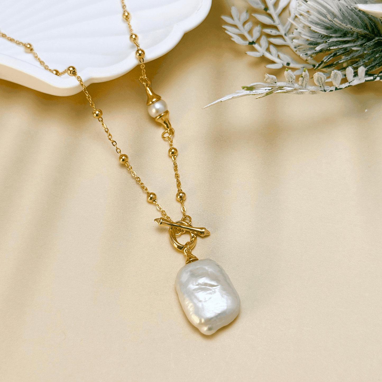 Gold vintage baroque pearl necklace with freshwater pearl pendant on a satellite bead chain and a toggle clasp, crafted in gold-plated sterling silver.