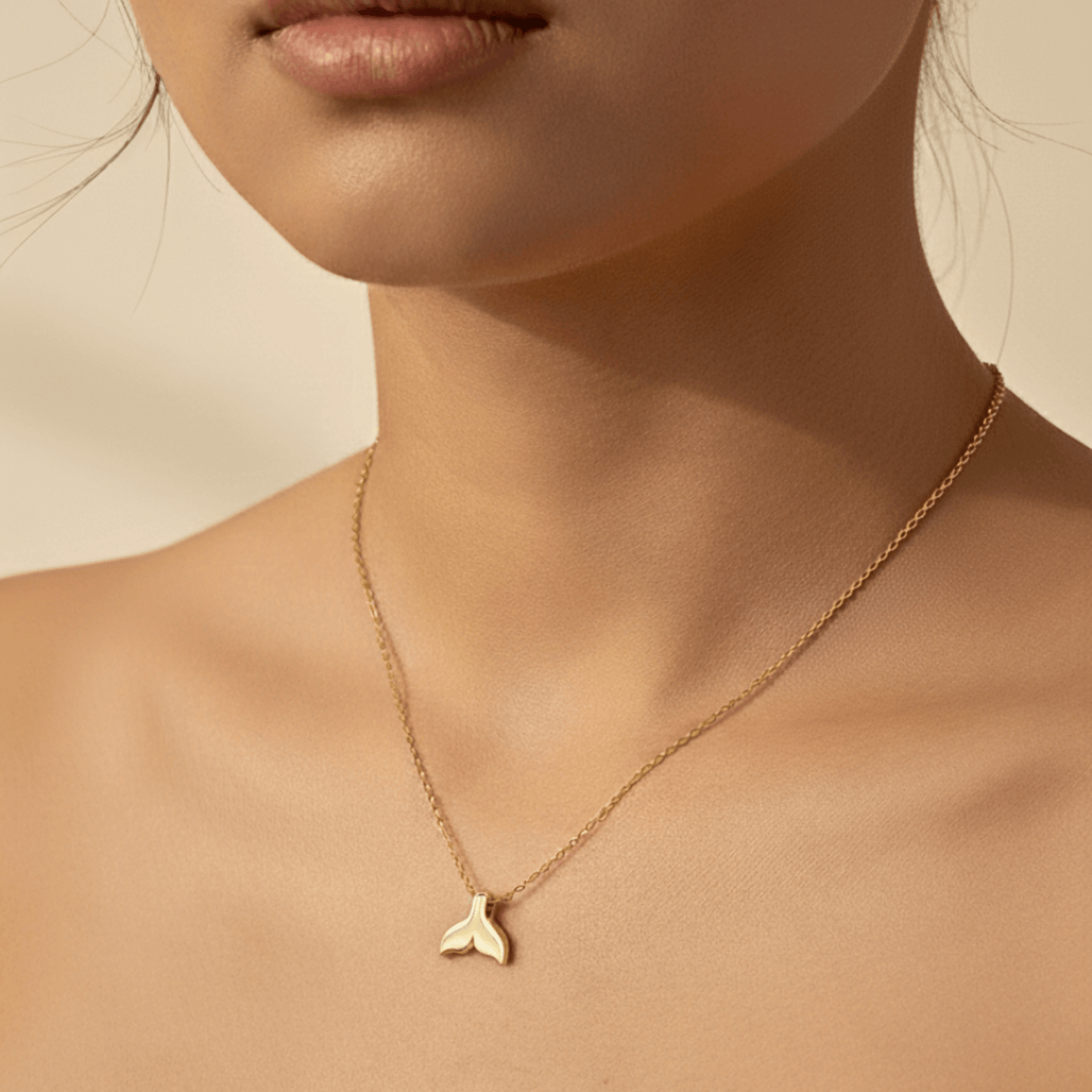 Gold whale tail pendant necklace symbolising ocean strength and freedom.